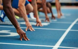 Track sprinters lined up at starting|スタートラインに並ぶ陸上短距離走者たち