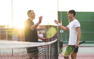 Father and Son Playing Tennis Outdoors.
