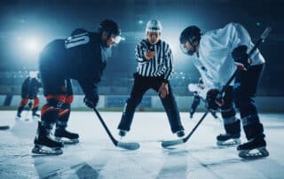 Ice Hockey Rink Arena Game Start: Two Players Brutal Face off, Sticks Ready, Referee is Going to Drop the Puck, Athletes Ready to Fight. Intense Game Wide of Energy Competition, Speed.