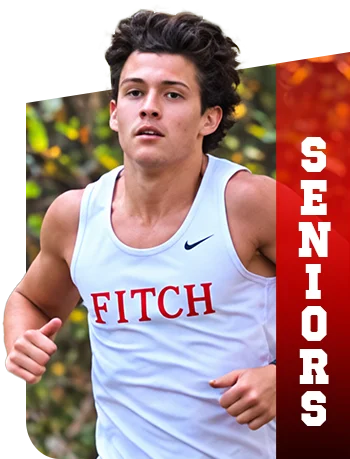 Young male cross country runner wearing a white Fitch jersey with a vertical red banner that says Seniors.